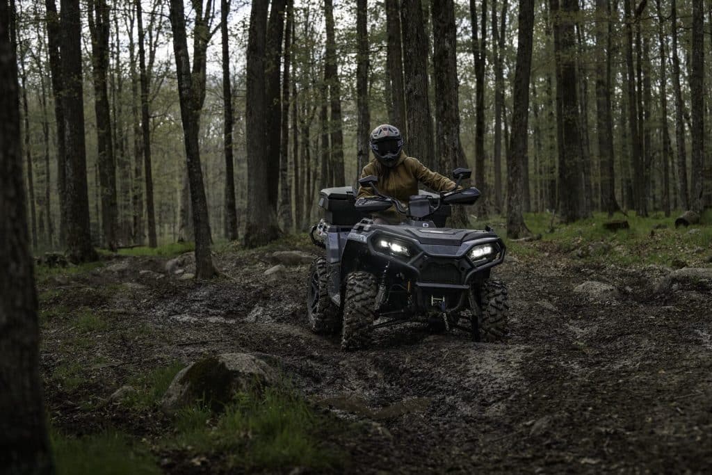 2027 Polaris Sportsman 500 riding a forest trail
